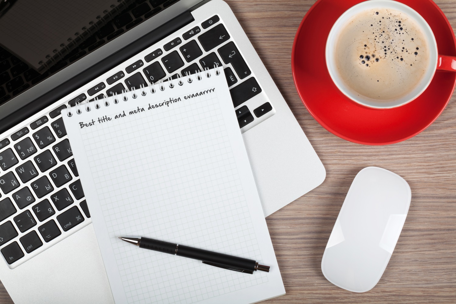 laptop with notebook, mouse, and coffee cup